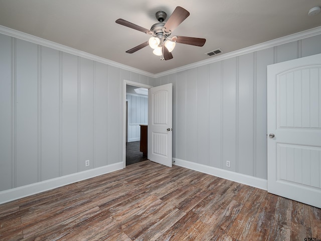 unfurnished bedroom featuring ornamental molding, ceiling fan, and dark wood-type flooring