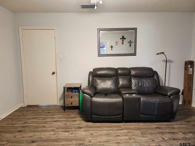 living room with wood-type flooring and a textured ceiling