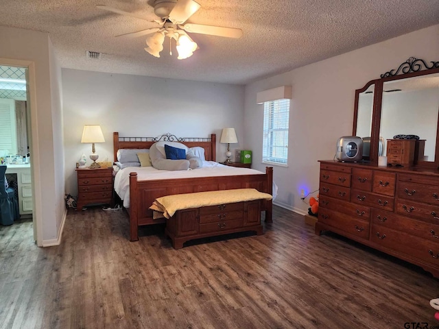 bedroom with dark wood-type flooring, ceiling fan, ensuite bath, and a textured ceiling