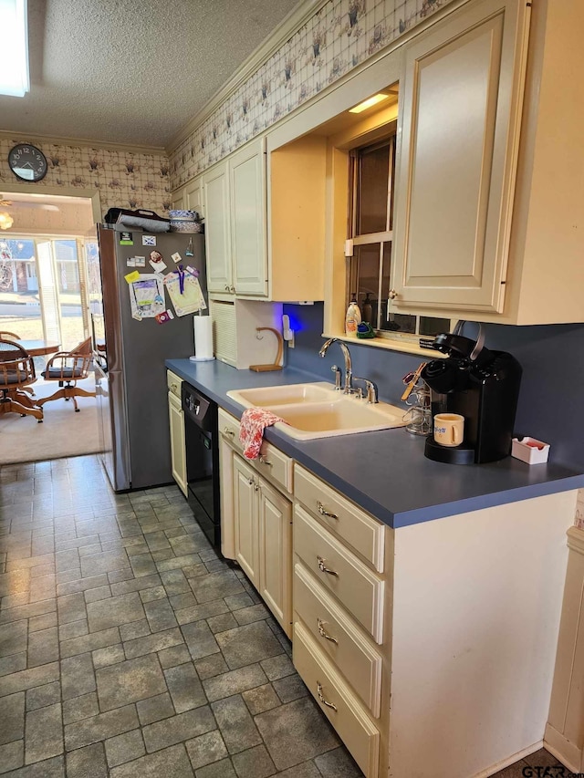 kitchen with wallpapered walls, black dishwasher, freestanding refrigerator, and a sink