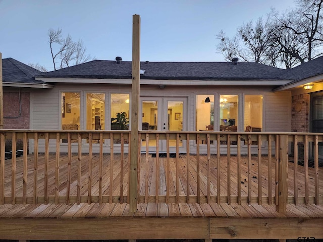 rear view of house with a shingled roof, brick siding, and a wooden deck