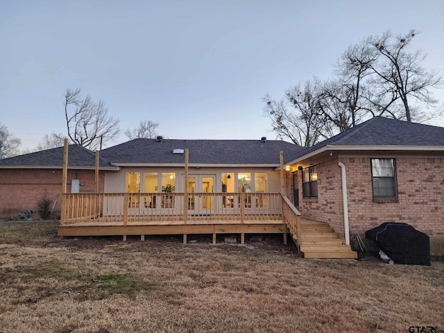 back of house with brick siding and a wooden deck