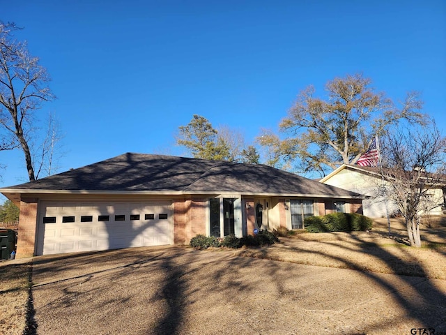 ranch-style home featuring brick siding, driveway, and a garage