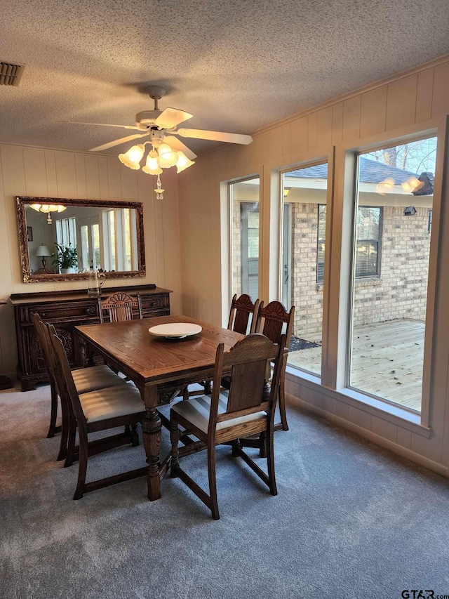 dining space featuring a wealth of natural light, visible vents, a textured ceiling, and carpet flooring