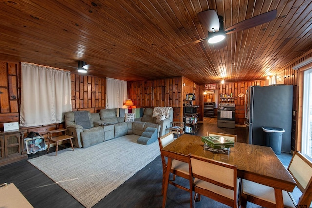 living room with ceiling fan, wooden ceiling, and wood walls