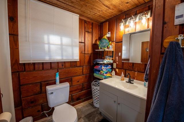 bathroom with vanity, toilet, wooden walls, and wood ceiling