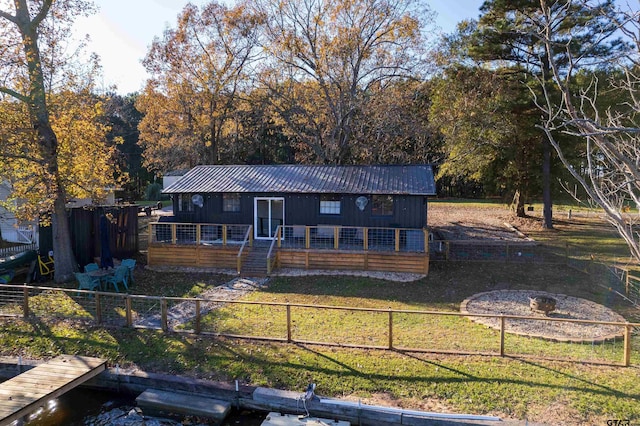 view of front of house with a dock and a front yard