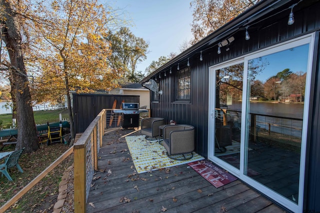 wooden deck featuring a water view and grilling area