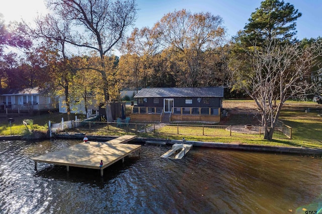 view of dock featuring a lawn and a water view