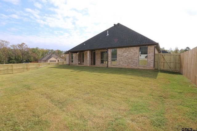 rear view of property featuring a yard