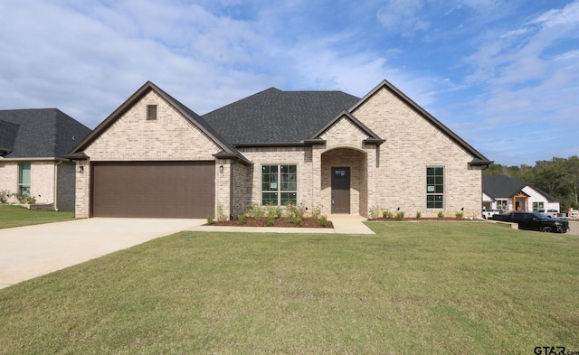 french country style house with a garage and a front yard