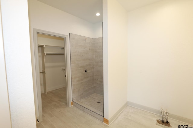 bathroom featuring a tile shower and hardwood / wood-style flooring