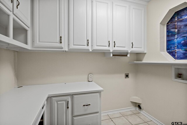 laundry area with electric dryer hookup, light tile patterned floors, washer hookup, and cabinets