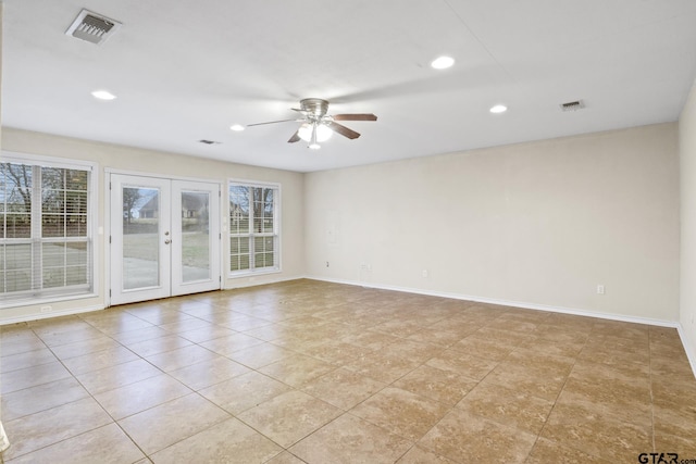 tiled spare room with plenty of natural light, ceiling fan, and french doors