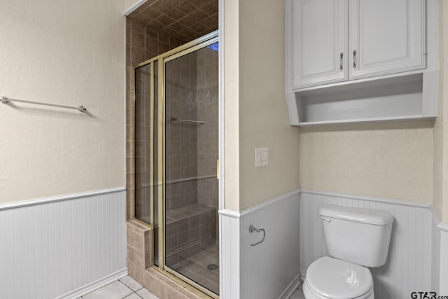 bathroom with an enclosed shower, tile patterned flooring, and toilet