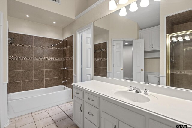 full bathroom featuring tiled shower / bath, tile patterned floors, toilet, and vanity