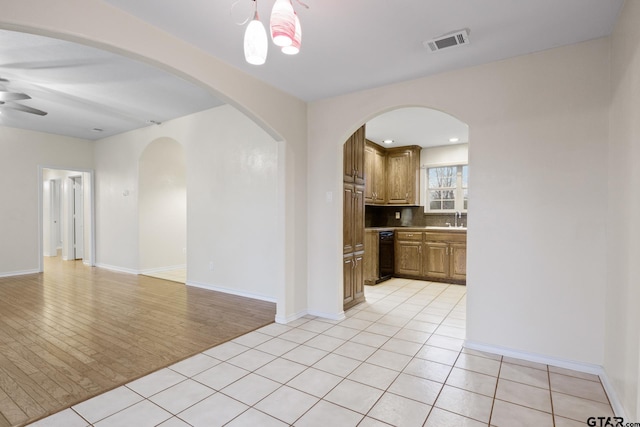 tiled spare room with ceiling fan and sink