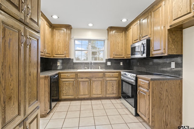 kitchen with tasteful backsplash, appliances with stainless steel finishes, sink, and light tile patterned floors