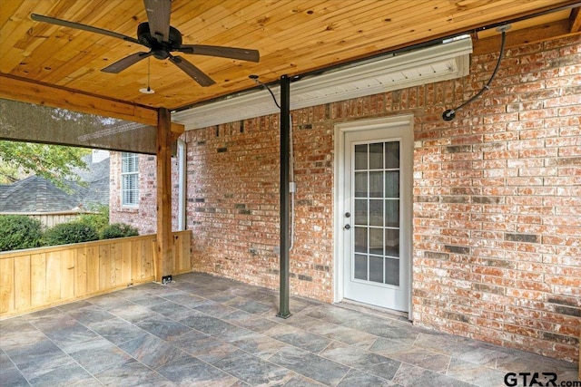 unfurnished sunroom with ceiling fan and wooden ceiling