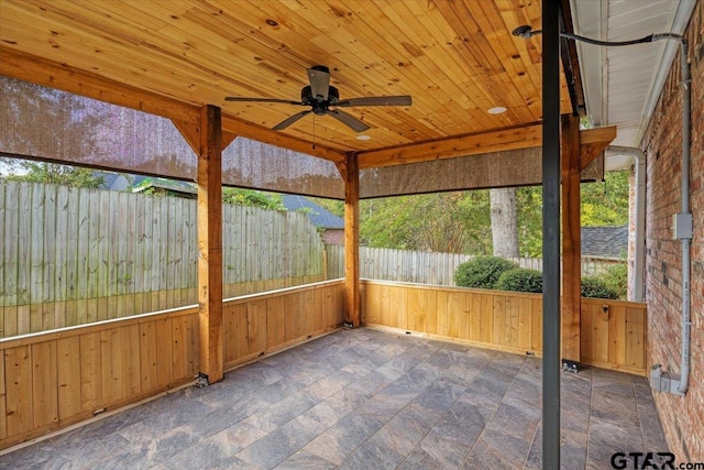 unfurnished sunroom with wood ceiling and ceiling fan