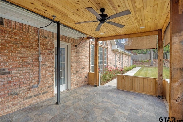 unfurnished sunroom with ceiling fan and wooden ceiling