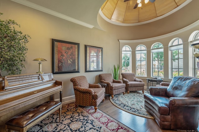 sitting room with ceiling fan, wood-type flooring, and crown molding