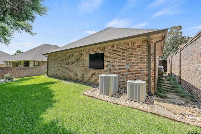 back of property with a yard and central AC unit