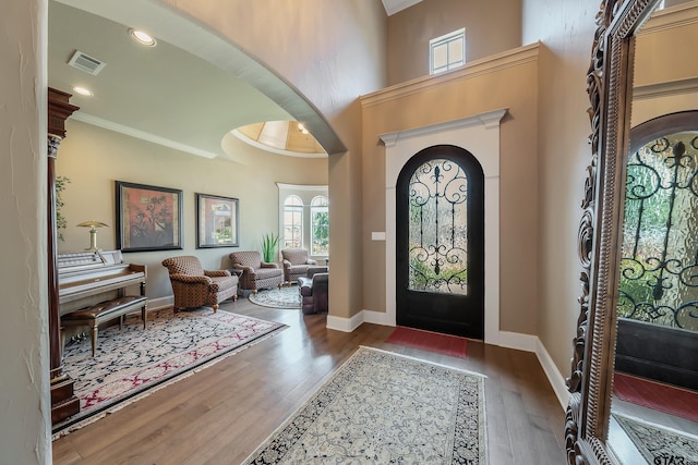 entrance foyer featuring crown molding, a high ceiling, and dark hardwood / wood-style floors