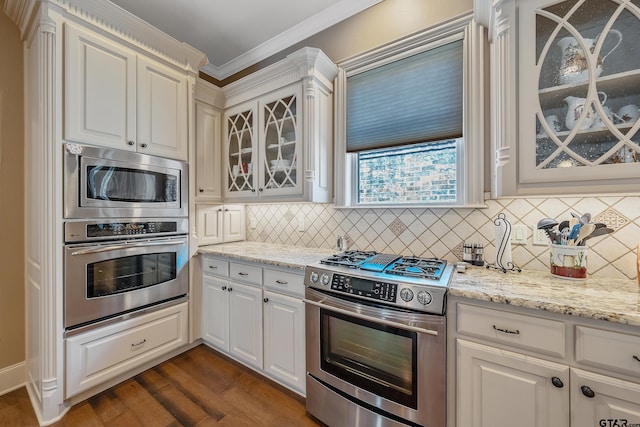 kitchen with white cabinets, appliances with stainless steel finishes, dark hardwood / wood-style floors, and ornamental molding