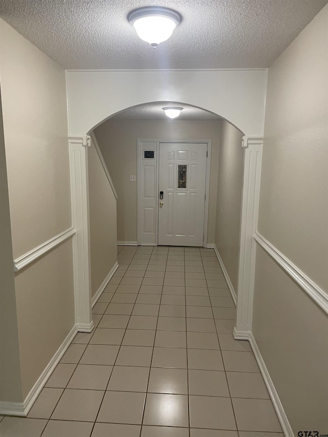 entryway with light tile patterned floors and a textured ceiling