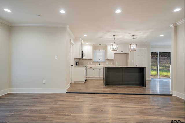 kitchen with ornamental molding, sink, white cabinetry, and hanging light fixtures