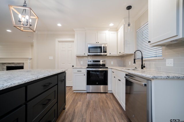 kitchen featuring sink, white cabinets, stainless steel appliances, and decorative light fixtures