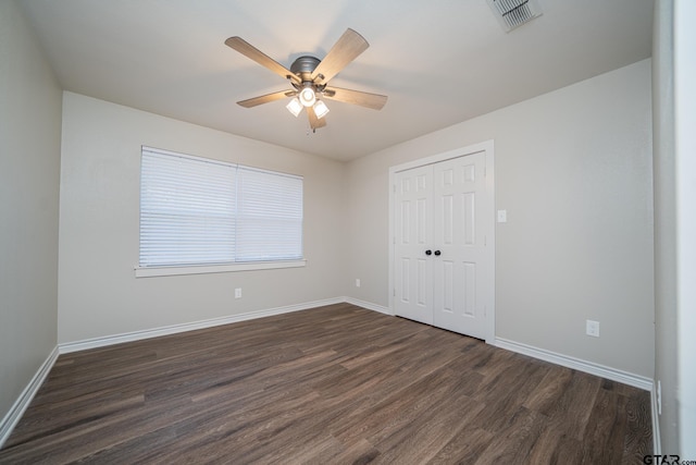 unfurnished bedroom with ceiling fan, a closet, and dark hardwood / wood-style flooring