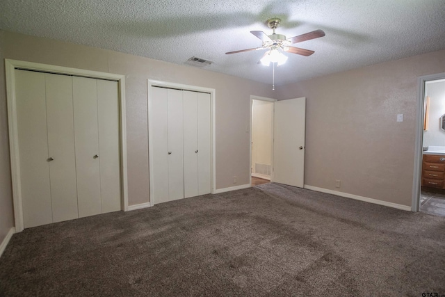 107 Clover Dr, Gun Barrel City, TX 75156 - unfurnished bedroom with two closets, carpet flooring, a textured ceiling, ensuite bath, and a ceiling fan