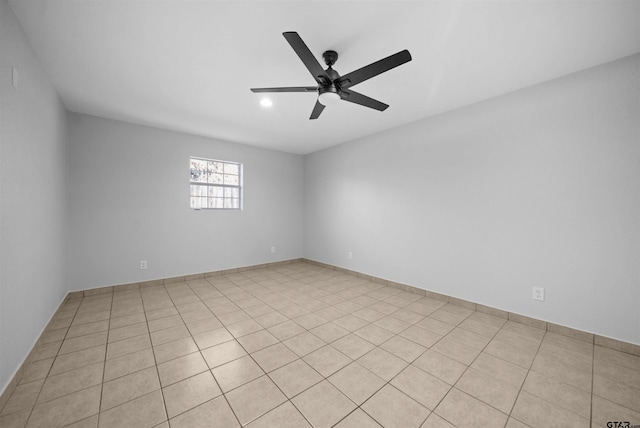 tiled spare room featuring ceiling fan