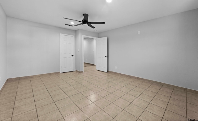 empty room with ceiling fan and light tile patterned flooring