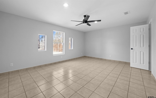 tiled spare room with ceiling fan