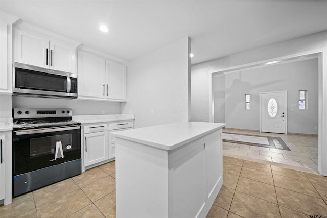 kitchen with white cabinetry, light tile patterned floors, and stainless steel appliances