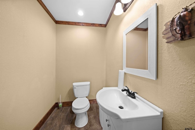 bathroom with toilet, vanity, and ornamental molding