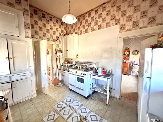 kitchen featuring light floors, hanging light fixtures, white cabinetry, white appliances, and wallpapered walls