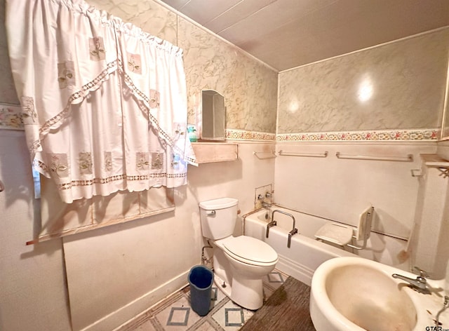 bathroom with toilet, a tub to relax in, and a sink