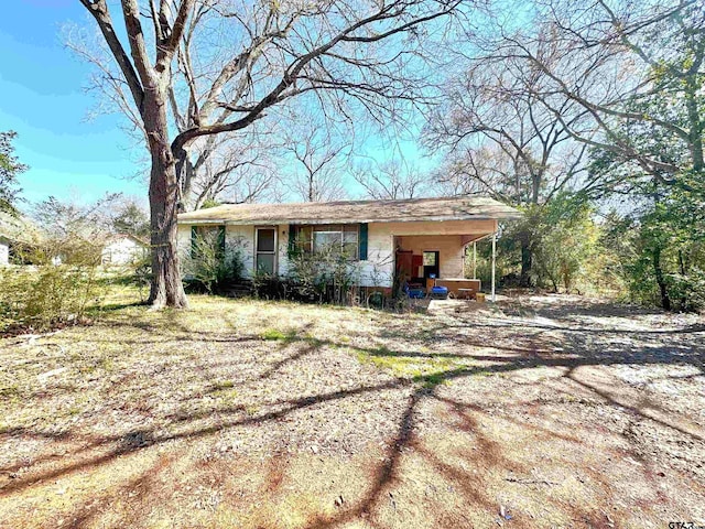 view of front facade with a porch and dirt driveway