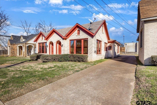 english style home with driveway and a front yard