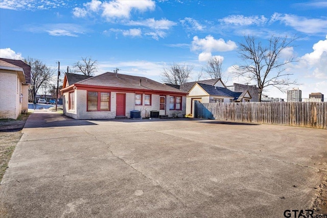 view of front of property with central AC unit, fence, and brick siding