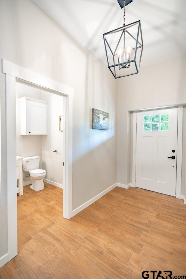 entrance foyer with an inviting chandelier and light hardwood / wood-style floors