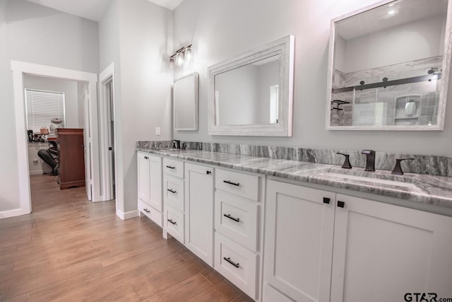 bathroom with vanity, wood-type flooring, and a shower with door