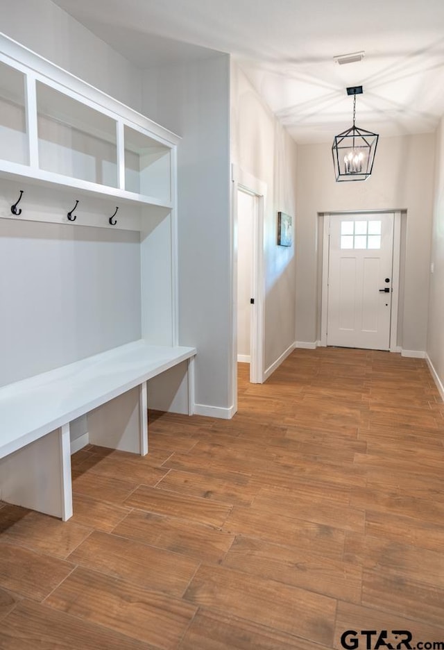 mudroom with hardwood / wood-style floors and a notable chandelier