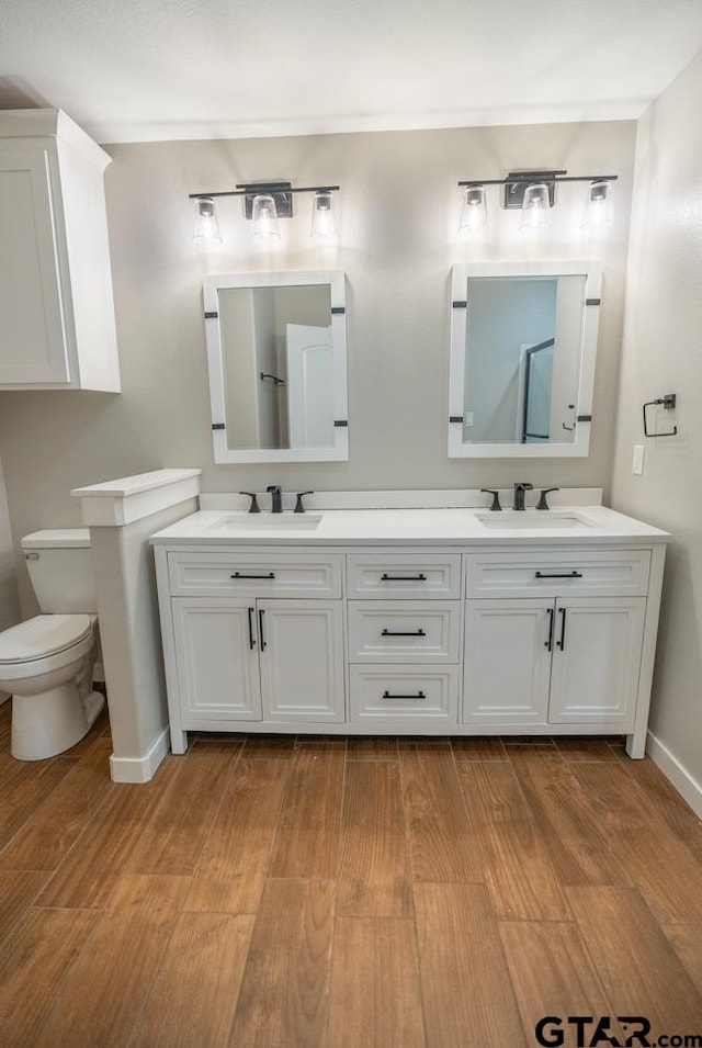 bathroom with vanity, hardwood / wood-style flooring, and toilet