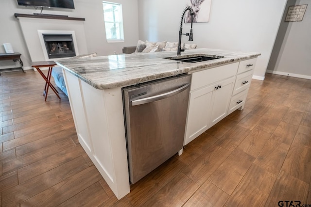 kitchen featuring white cabinets, hardwood / wood-style flooring, sink, a kitchen island with sink, and stainless steel dishwasher