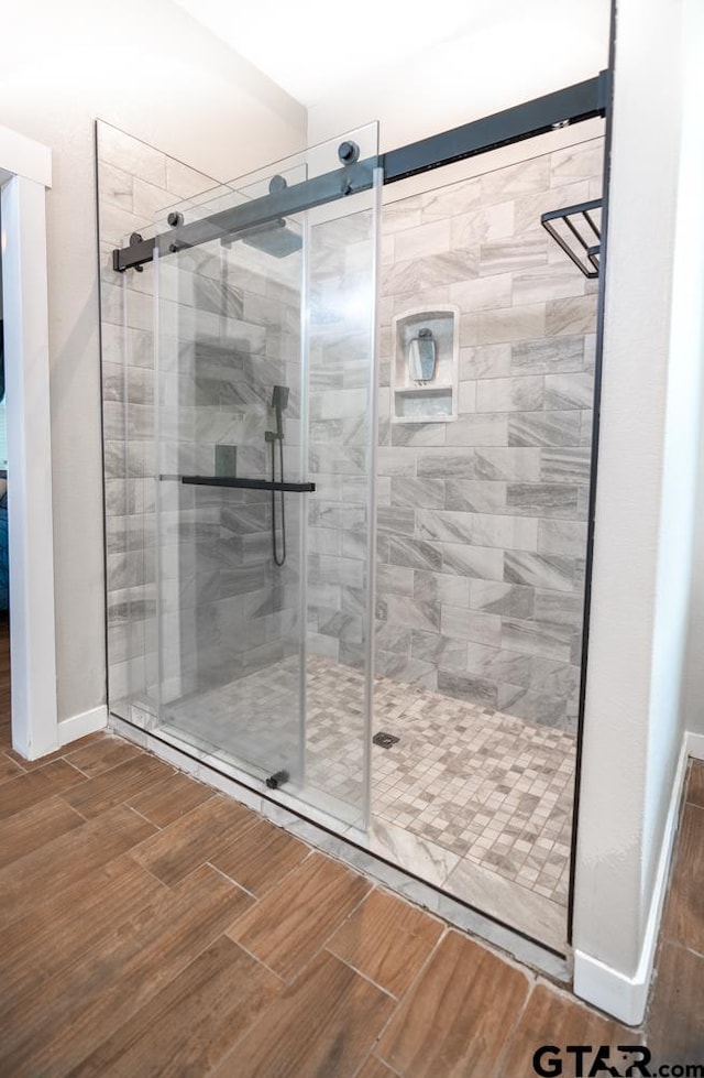 bathroom featuring a shower with door